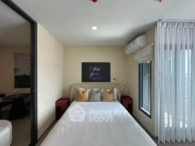 Modern bedroom with stylish decor and natural light, featuring a cozy bed and air conditioning.