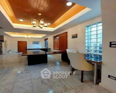 Spacious modern living room with elegant marble flooring and stylish wooden ceiling.