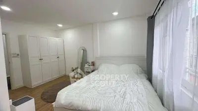 Bright and cozy bedroom with modern furnishings and ample natural light.