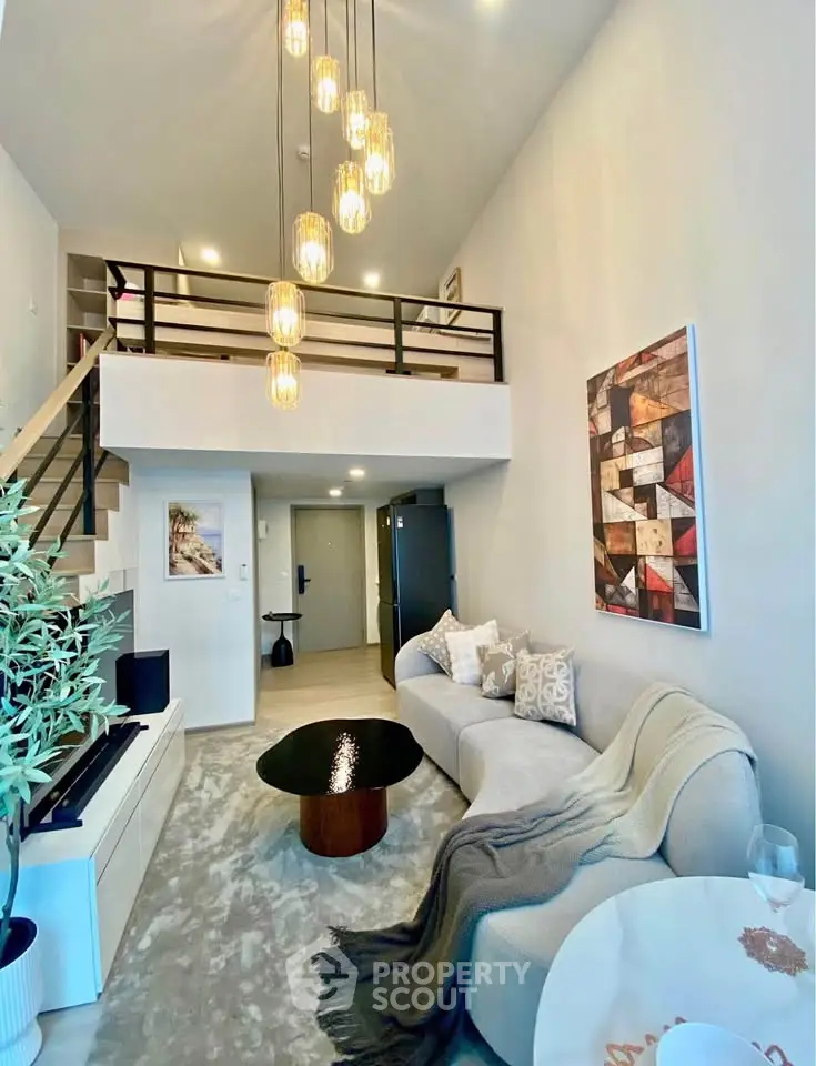 Stylish loft living room with modern decor and high ceilings, featuring a cozy sofa and elegant lighting.