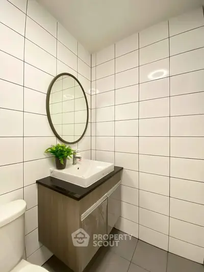 Modern bathroom with sleek vanity and round mirror, perfect for stylish living.