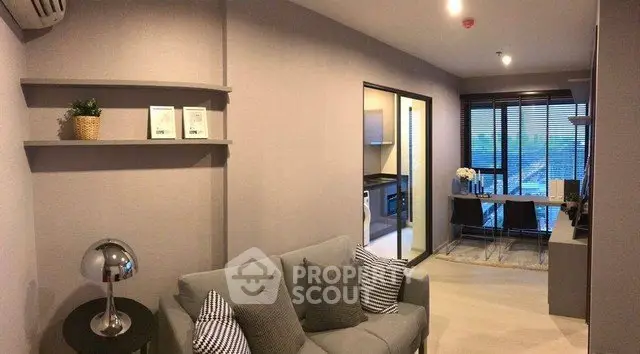 Modern living room with cozy sofa and dining area, featuring large windows and stylish decor.