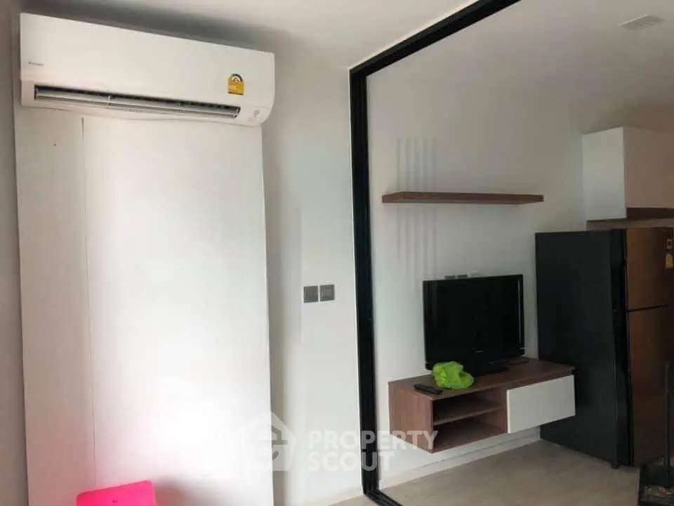 Modern living room with air conditioning and sleek TV setup in a stylish apartment.