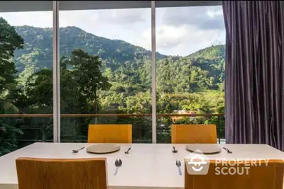 Stunning dining area with panoramic mountain views through large windows.