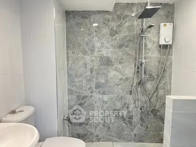 Modern bathroom with sleek shower and elegant gray tile design.