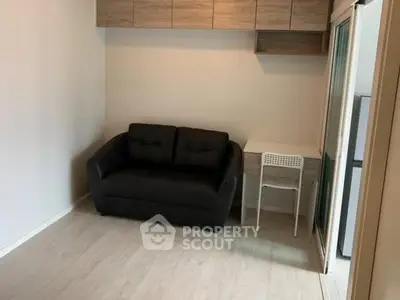 Cozy living room with black sofa and compact workspace