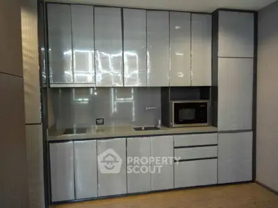 Modern kitchen with sleek cabinetry and built-in microwave