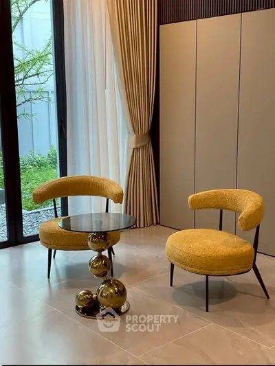 Stylish modern living room with chic yellow chairs and elegant glass table.