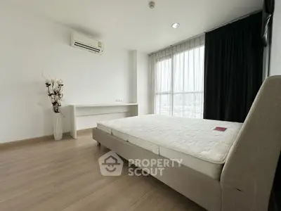 Spacious modern bedroom with large window and minimalist decor