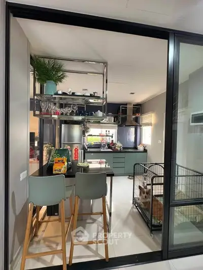 Modern kitchen with sleek design, featuring open layout and stylish bar seating.