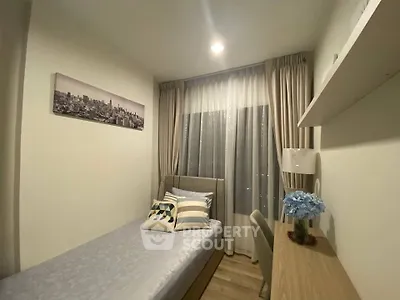 Cozy bedroom with modern decor and city view, perfect for urban living.