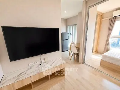 Modern apartment interior with TV, dining area, and bedroom view
