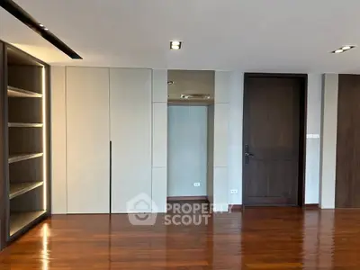 Spacious modern interior with wooden flooring and built-in shelving, ideal for stylish living.