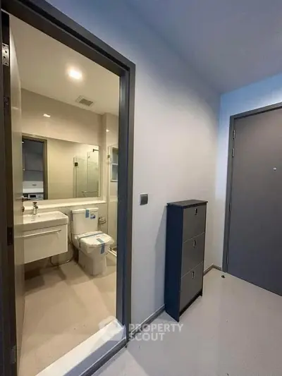 Modern apartment entrance with adjacent bathroom view