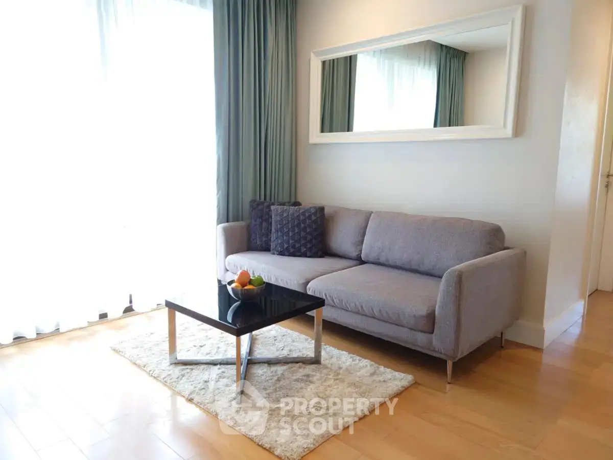 Stylish living room with modern sofa, elegant mirror, and natural light