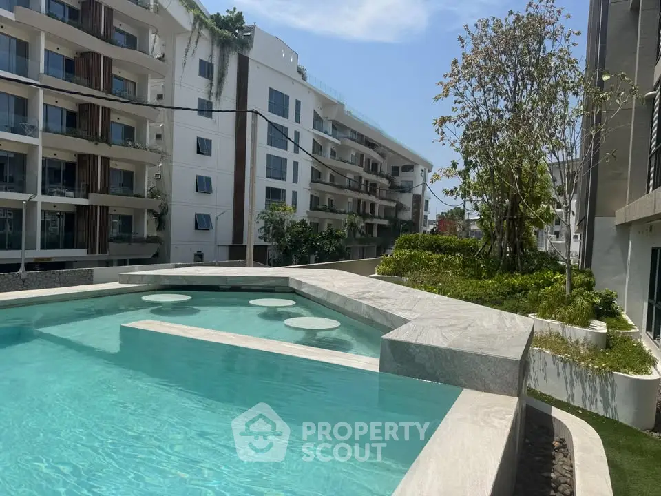 Luxurious apartment complex with modern pool and lush greenery, perfect for upscale living.