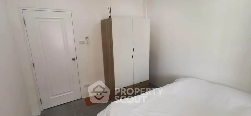 Cozy bedroom with minimalist wardrobe and white bedding