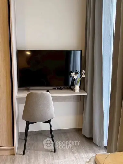 Modern living room corner with TV and stylish chair, perfect for cozy relaxation.