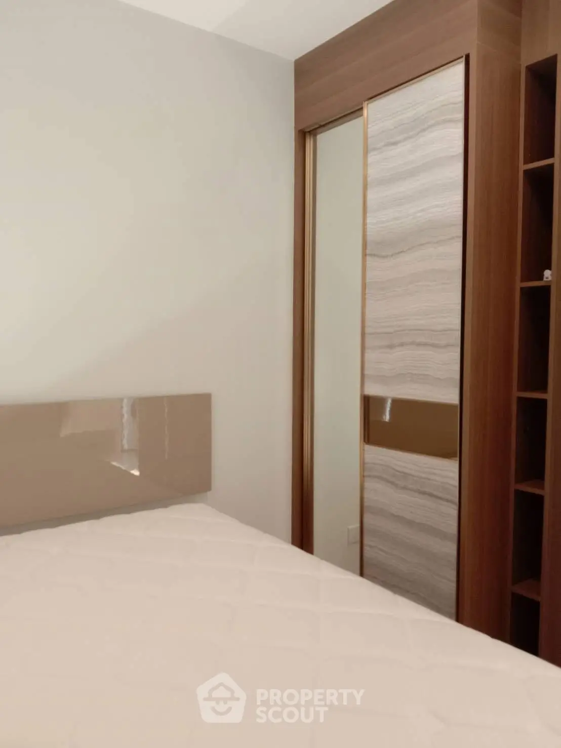 Modern bedroom with sleek wardrobe and stylish headboard, perfect for contemporary living.