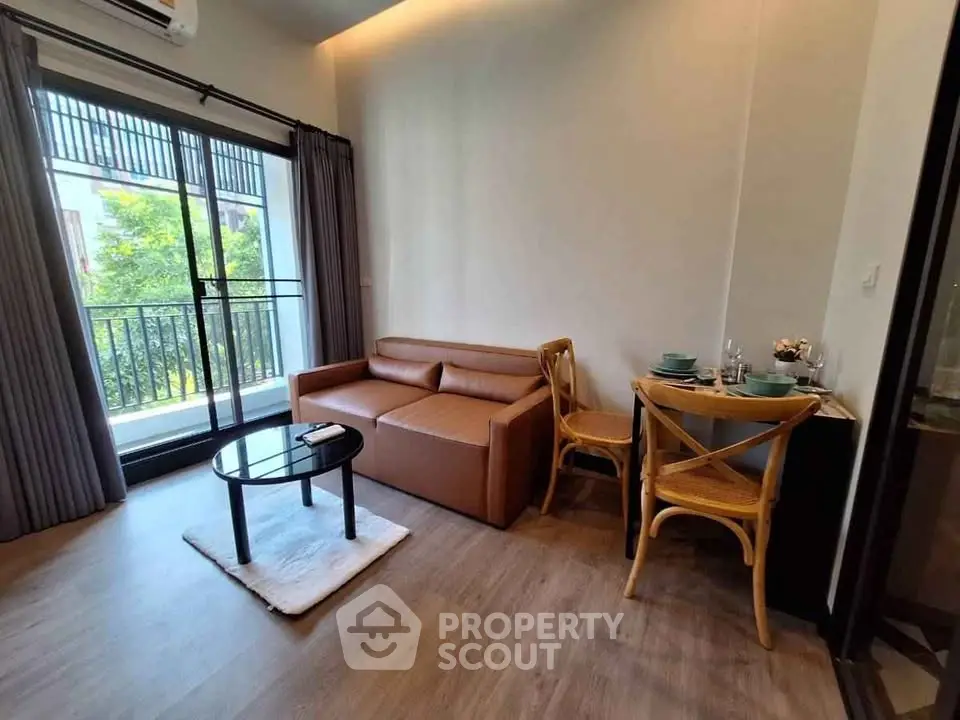 Cozy living room with balcony view, featuring modern furniture and natural light.