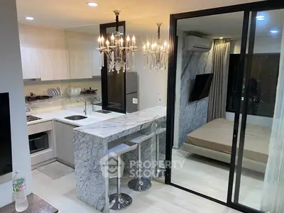 Modern open-plan kitchen with marble countertop and cozy bedroom view