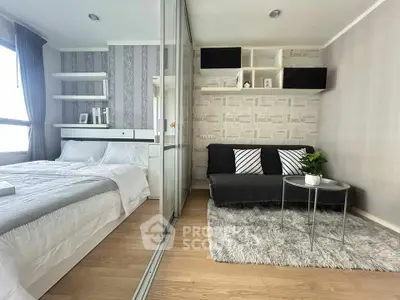 Modern bedroom with stylish decor and cozy seating area, featuring a large window and elegant wallpaper.