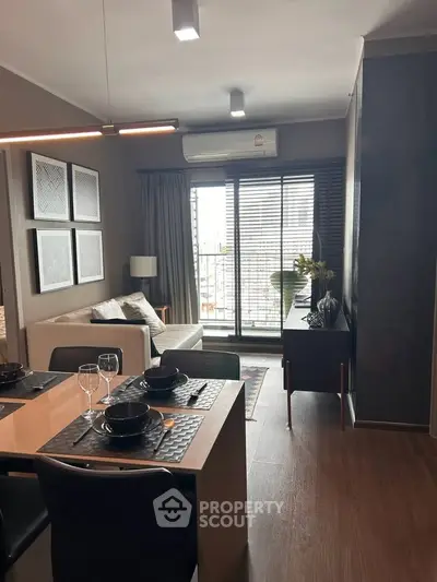 Modern living room with dining area and balcony access, featuring stylish decor and natural light.