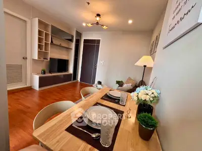 Modern living room with dining area, wooden flooring, and stylish decor in a cozy apartment.