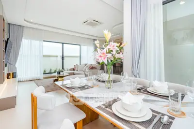 Luxurious dining area with elegant table setting and bright natural light in modern apartment.