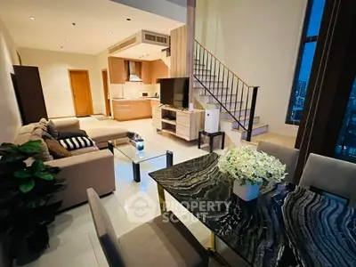 Luxurious modern living room with open kitchen and elegant staircase in a high-rise apartment.