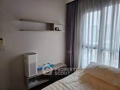 Cozy bedroom with modern air purifier and natural light through large window.