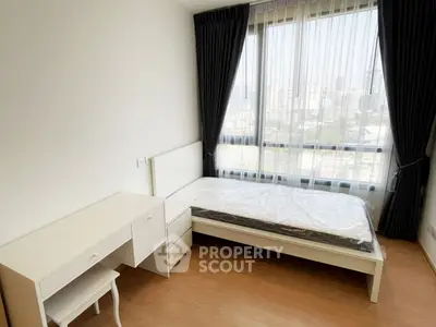 Bright bedroom with large window and city view, featuring a desk and bed with modern furnishings.