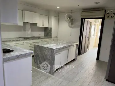 Modern kitchen with marble countertops and sleek white cabinets