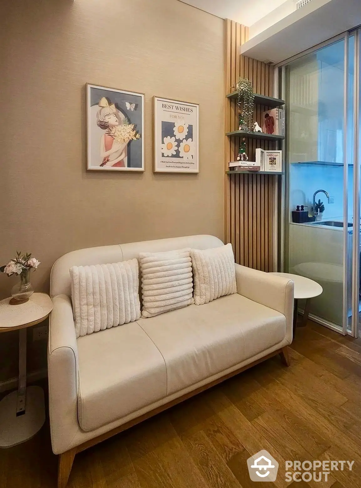 Cozy living room with modern decor, elegant white sofa, wooden flooring, and tasteful wall art, perfect for relaxation and social gatherings.