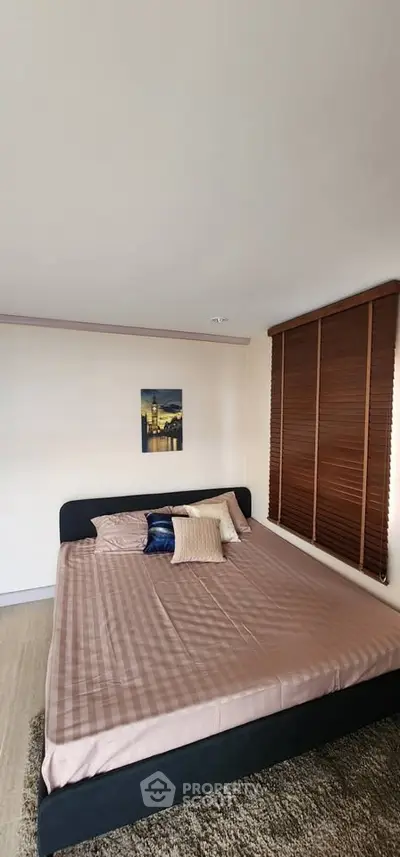 Spacious bedroom with large bed and cozy decor in modern apartment.