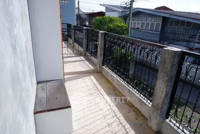 Charming balcony with wrought iron railing and street view, perfect for relaxation.