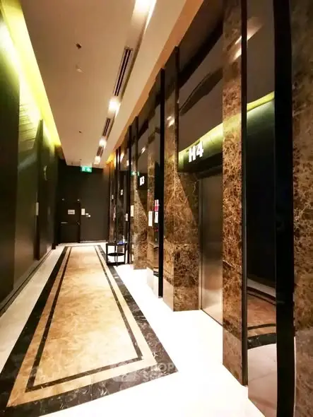 Luxurious building elevator lobby with marble finishes and modern lighting.