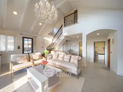 Luxurious living room with high ceilings, elegant chandelier, and stylish decor in a modern home.