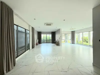 Spacious modern living room with large windows and marble flooring