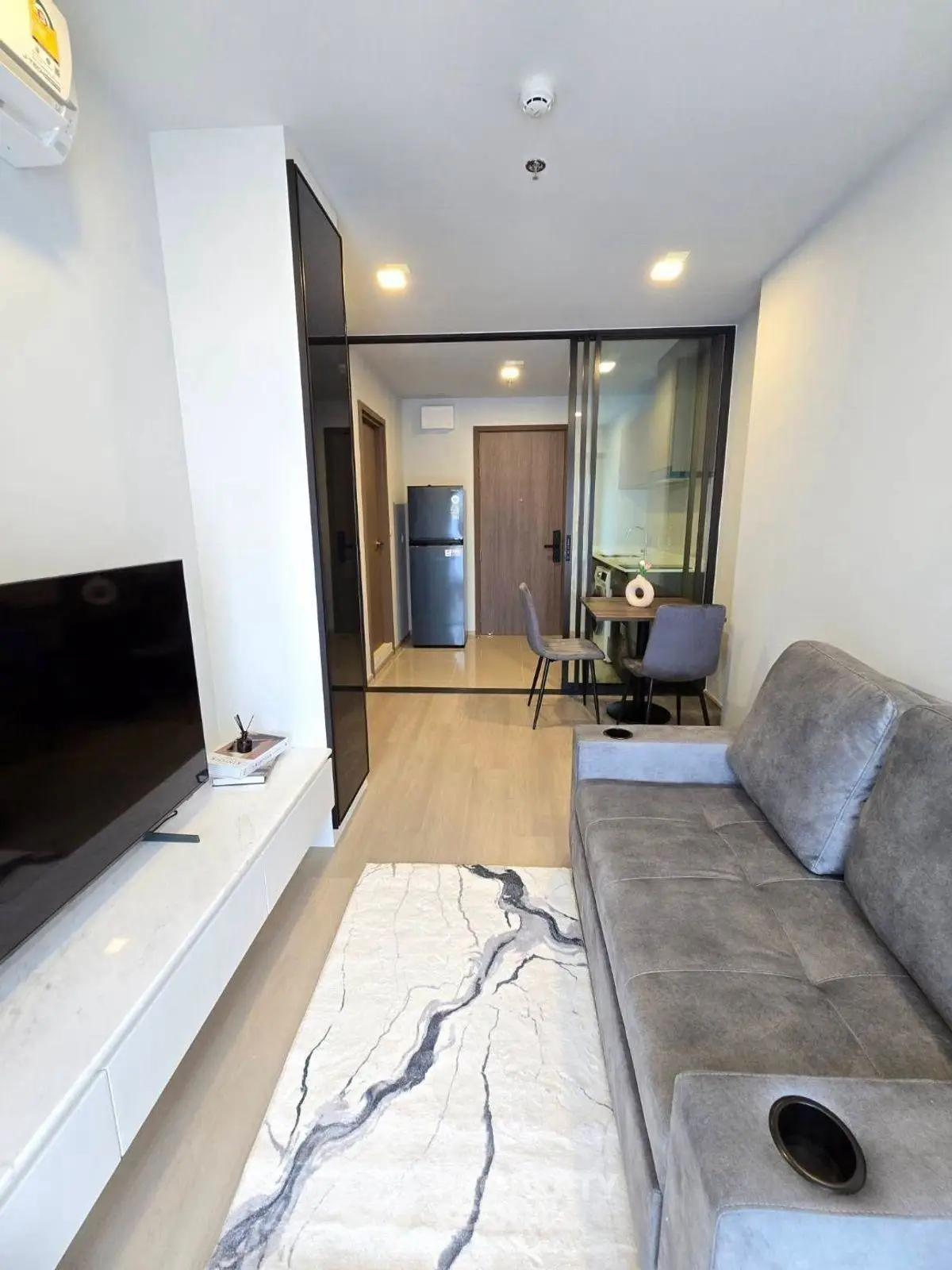 Modern living room with sleek furniture and open kitchen layout in a stylish apartment.