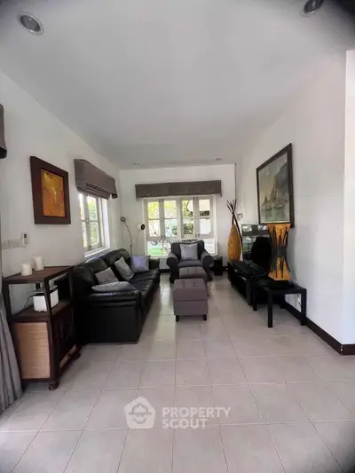 Spacious living room with elegant decor and natural light, perfect for relaxation and entertaining.