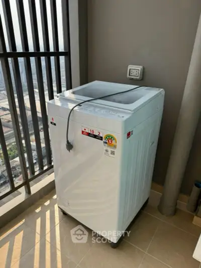 Modern washing machine on a balcony with city view, perfect for urban living convenience.