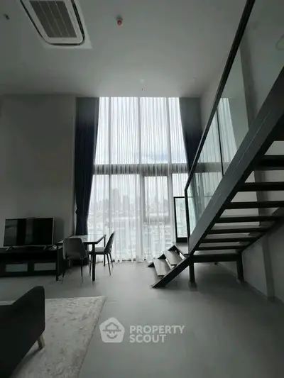 Stunning modern loft with high ceilings and large windows offering a breathtaking city view.