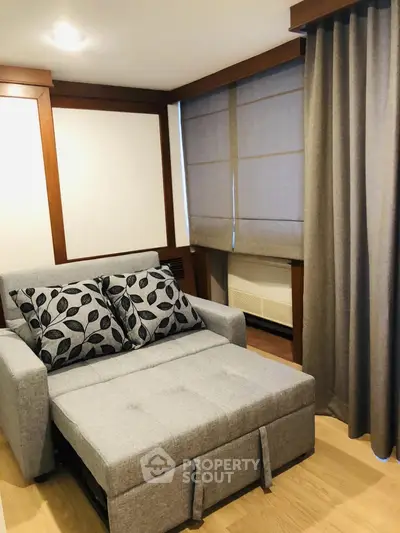 Cozy living room with stylish sofa bed and elegant curtains in modern apartment.