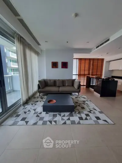 Modern living room with stylish decor and open kitchen layout in luxury apartment.
