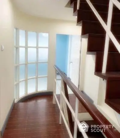 Modern staircase with wooden steps and glass block wall in a stylish home interior.