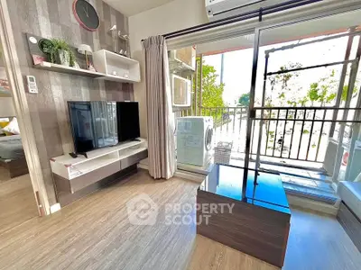 Modern living room with balcony, featuring sleek furniture and natural light.
