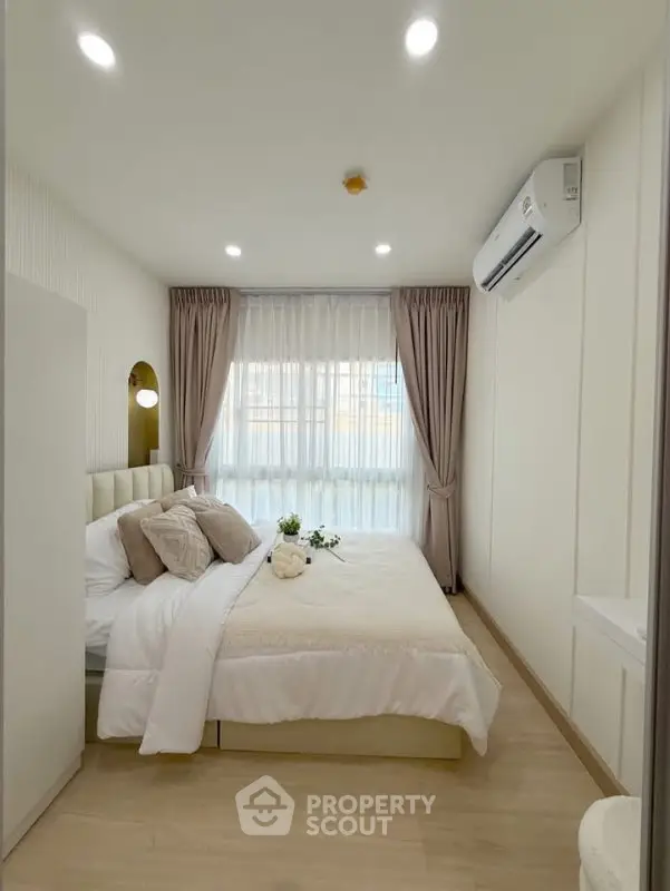 Elegant bedroom with cozy decor and natural light, featuring a comfortable bed and modern air conditioning.