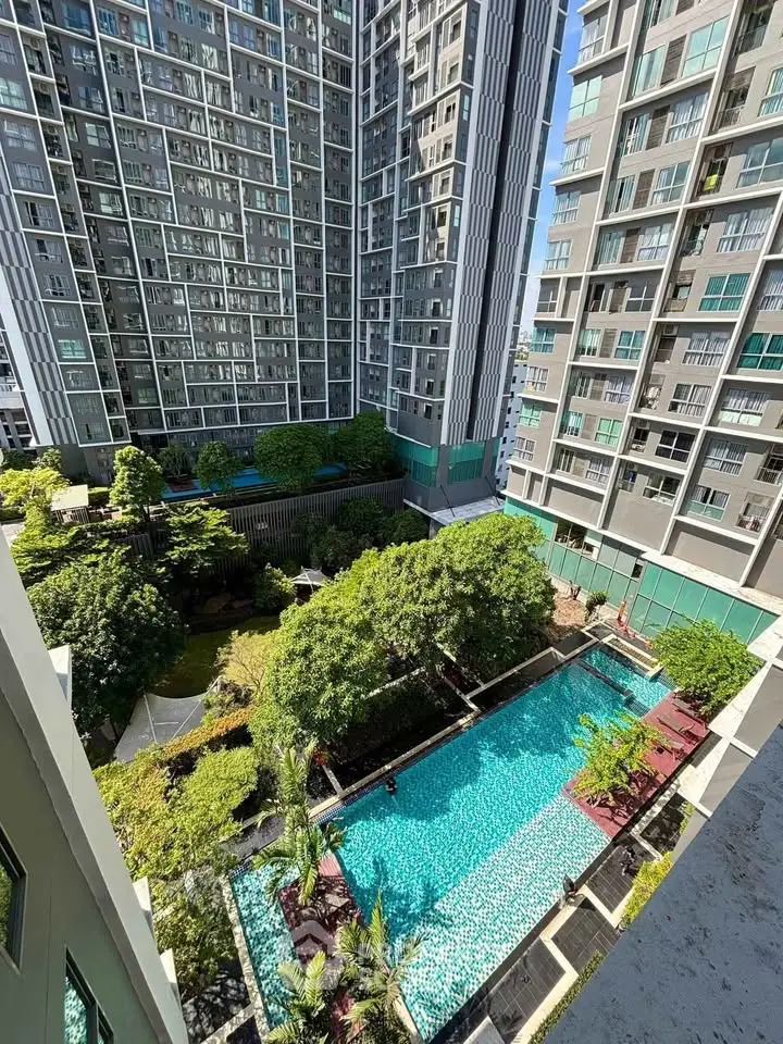Luxurious high-rise apartment complex with stunning pool and lush garden view.