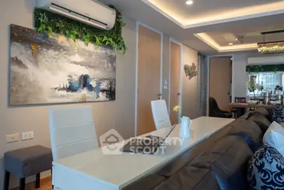 Modern living room with stylish decor and open layout, featuring a sleek dining area and contemporary artwork.